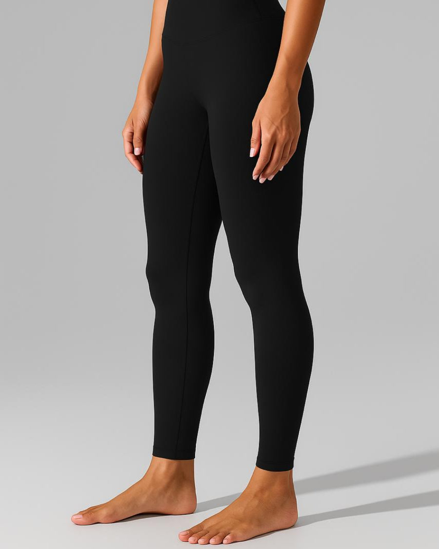 Person wearing black leggings on a gray background