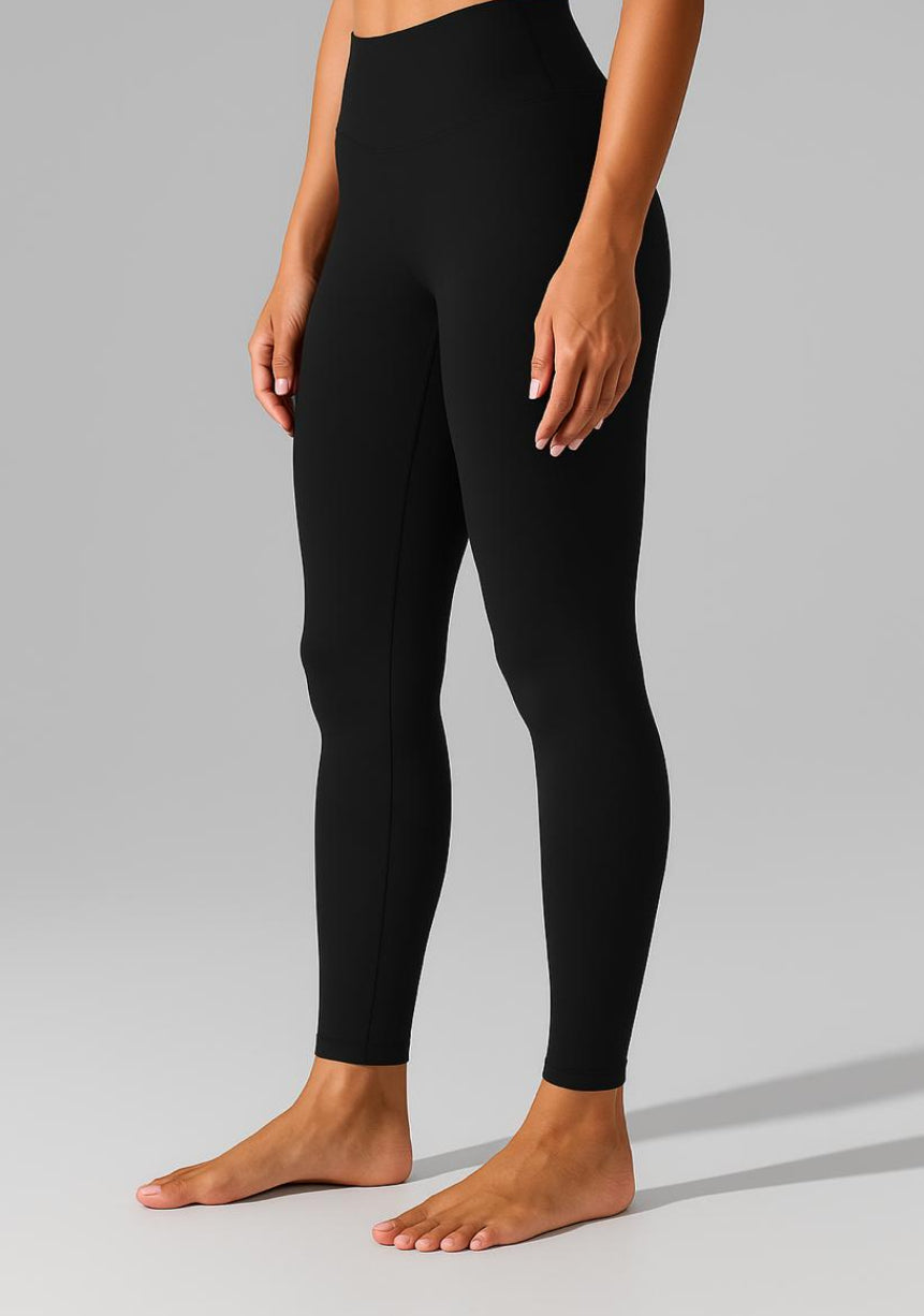 Person wearing black leggings on a gray background