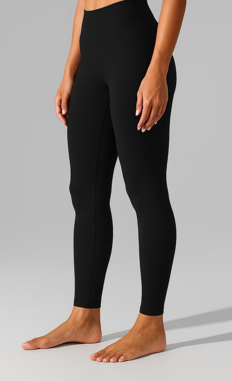 Person wearing black leggings on a gray background