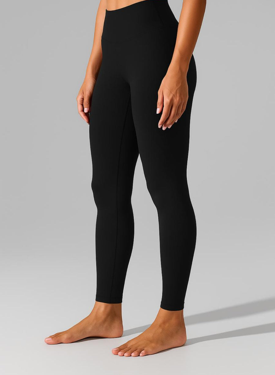 Person wearing black leggings on a gray background