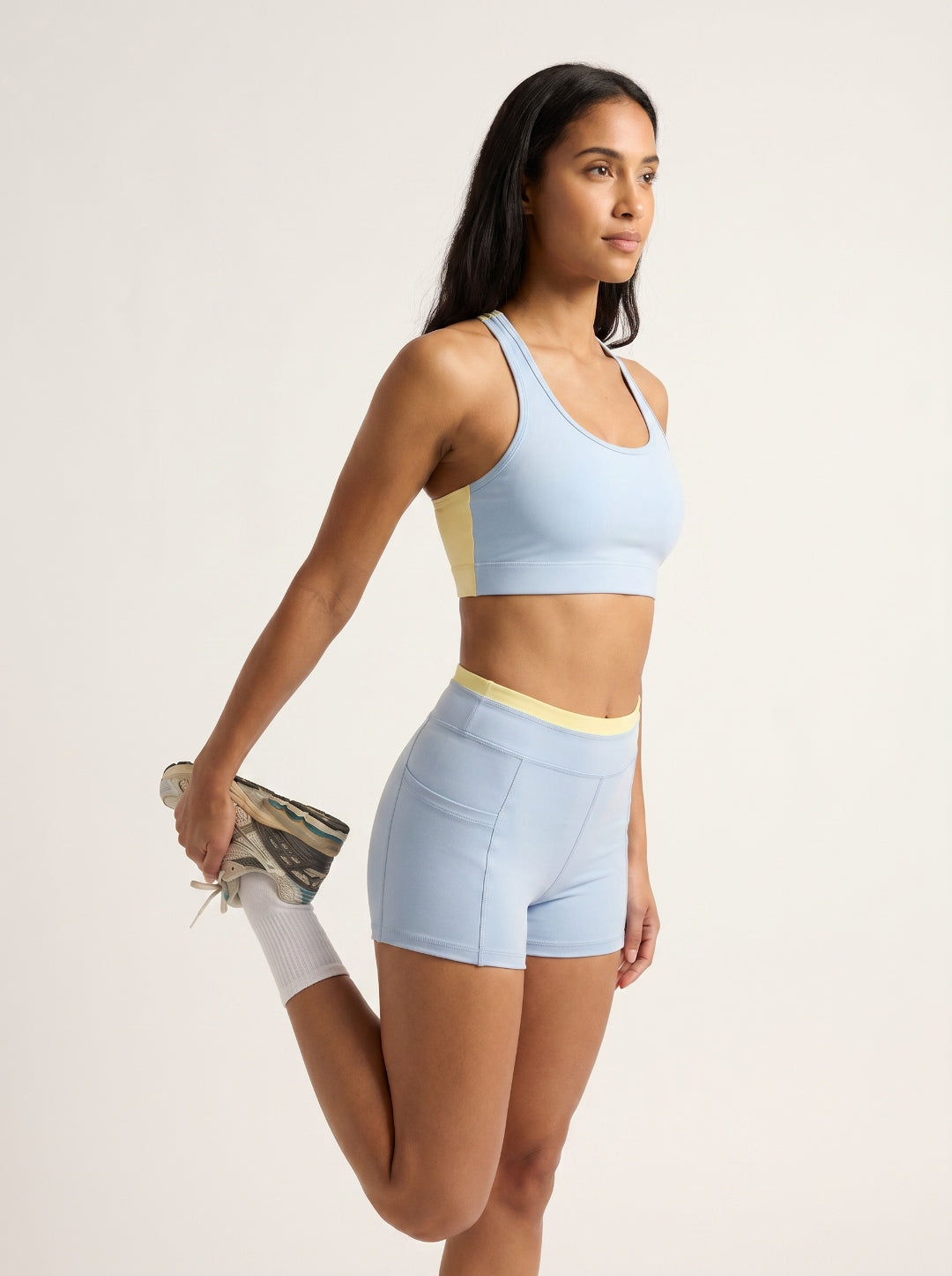 Skyline Reversible Set in motion β Horizon Blue sports bra and biker shorts on Indian model stretching