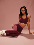 Aurora burgundy racerback sports bra and matching burgundy leggings on model — Summer 26 hero