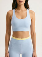 Skyline Reversible Sports Bra closeup — Horizon Blue scoop neck racerback with butter yellow reversible back
