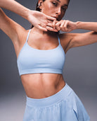 Model wearing the Tidewave Ribbed Sports Bra in Horizon Blue with a matching skort